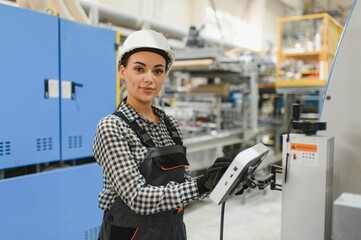 Female industrial worker operating machinery in factory setting