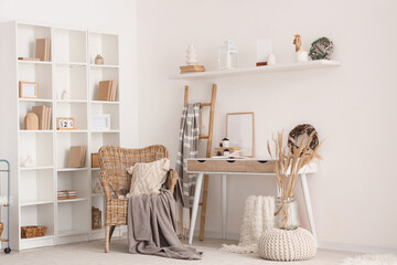 Light interior of room with table, wicker armchair and winter decor
