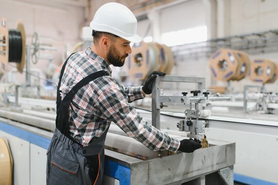 Factory worker operating machinery for pvc window production - Powered by Adobe