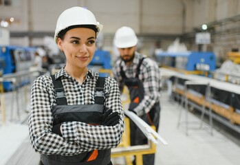 Portrait of female engineer smiling with arms crossed in a modern factory