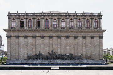 Back view of Teatro Degollado in Guadalajara, Mexico, featuring neoclassical architecture and a historic bronze relief sculpture in the foreground