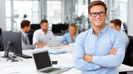 Confident young businessman smiling with arms crossed in a modern office environment