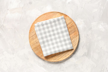 Wooden plate with napkin on white grunge table, top view