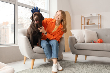 Young woman brushing her cute dog at home