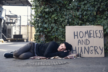 Homeless man with cardboard sleeping on street