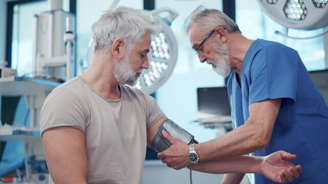 Doctor taking patient's blood pressure using digital blood pressure monitor.