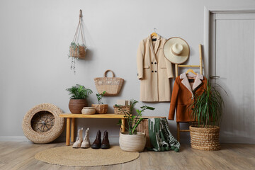 Interior of hallway with wicker baskets, bench and coats