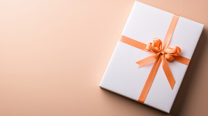 Beautifully wrapped gift box with orange ribbon on soft beige background, perfect for any occasion