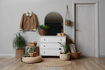 Interior of hallway with wicker baskets, mirror and plants