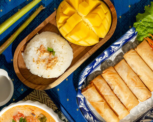 Authentic Thai feast with golden mango, jasmine rice, and crispy spring rolls, evoking Songkran celebration and culinary wanderlust