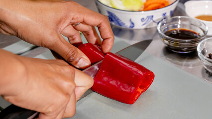 Spicy red pepper sliced by skilled hands, culinary creation zone, vibrant Asian kitchen, Lunar New Year feast