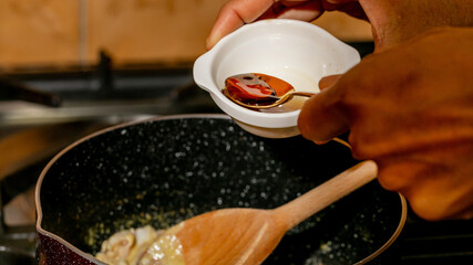 African American hands sprinkle saffron essence, culinary alchemy unfolds, Kwanzaa feast resonates, aromatic whispers in kitchen symphony