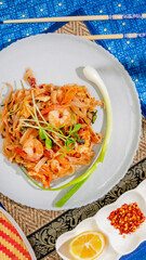 Sizzling shrimp entwined with tangy noodles, evoking Songkran feasting, vibrant spice symphony, culinary journey through Thailand's tapestry