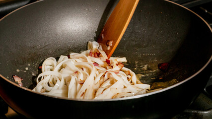 Stirring sizzling rice noodles dances in hot wok, evoking Lunar New Year feasts, Singapore's...