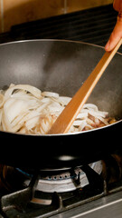 Sizzling onions in a wok dance under a wooden spatula, evoking Lunar New Year zest and culinary alchemy