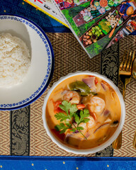 Steaming Thai tom yum soup with vibrant lemongrass symphony, culinary tapestry celebrating Songkran, Asian festivity, golden cutlery gleam