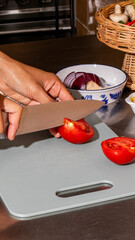 A meticulous hand of Middle Eastern descent slices vibrant tomatoes, culinary alchemy, echoing...