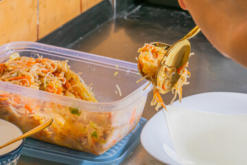 Golden-swirled fork embraces vibrant kimchi and noodles, evoking Korean Harvest Moon Festival,...