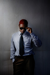 Portrait of a Latin American guy taking off sunglasses in executive suit