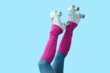 Legs of woman in roller skates on blue background. Summer party