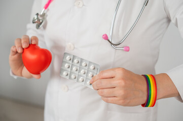 Doctor with rainbow bracelet holding heart and blister of pills. Concept of health care during gender transition. 