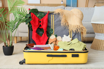 Open suitcase with beach accessories in living room