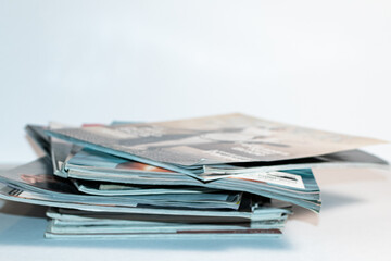 Periodicals, reading materials and magazines stacked on top of each other messily. 