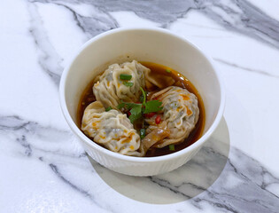 deep fried crispy Xiao long bao Shanghai small meat dumpling wanton jiao zhi in plate with spicy chilli ginger vinegar on white marble table dim sum halal food breakfast menu for china Hong Kong cafe
