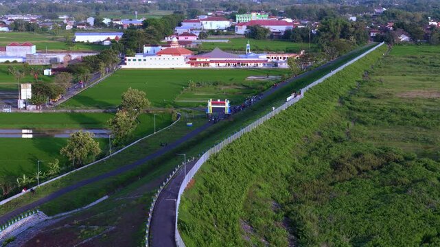 Aerial view of rural town with winding highway cutting through green fields and scattered buildings
