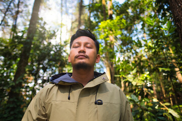 Man Relaxing in Forest With Sunlight Passing Through Trees