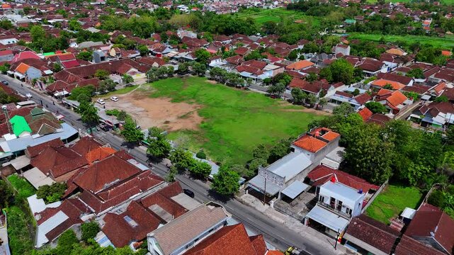 Aerial view of a field surrounded by homes. Drone orbit shot.
