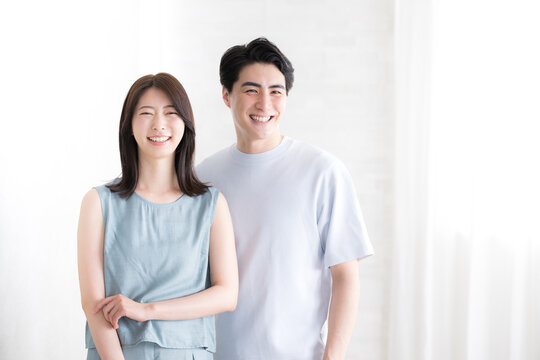 夏服のカップルのカメラ目線の笑顔白背景　右にコピースペースあり