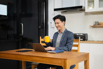 Lifestyle people, using laptop computer and smartphone sitting in the kitchen. Happy mature male,...