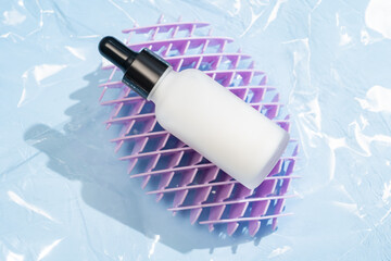 White dropper bottle with beauty serum on blue background