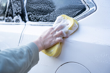 washing a dirty car and wheels with water and a pressure washer
