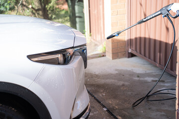 washing a dirty car and wheels with water and a pressure washer