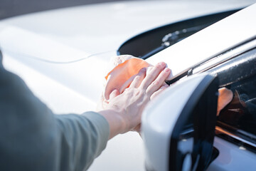 washing a dirty car and wheels with water and a pressure washer