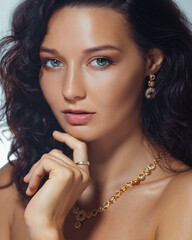 Close-Up Beauty Portrait of Woman Wearing Gold Earrings, Ring and Necklace