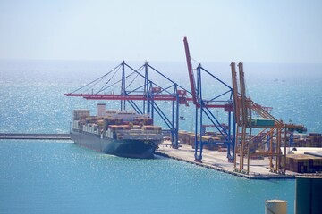 container cargo freight ship in port getting loaded with cranes, shipping, globalization, sea...