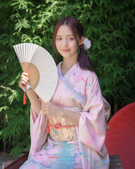 A pretty young Asian Japanese woman in a Traditional Yukata Dress. A young Asian girl wearing a...
