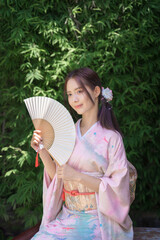 A pretty young Asian Japanese woman in a Traditional Yukata Dress. A young Asian girl wearing a...