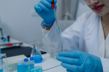 a female scientist is working in lab, a chemist tests liquid sample in science laboratory, she...