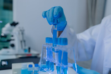 a female chemist is testing various liquid compounds in a lab, a scientist is doing research on the...