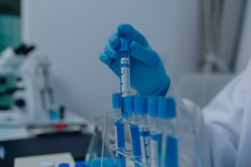 a female chemist is testing various liquid compounds in a lab, a scientist is doing research on the...