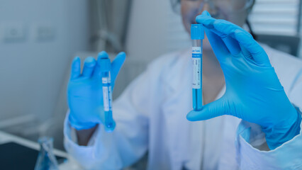 a female scientist is working in lab, a chemist tests liquid sample in science laboratory, she...