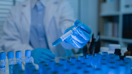 a female chemist is testing various liquid compounds in a lab, a scientist is doing research on the...