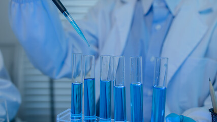 a female chemist is testing various liquid compounds in a lab, a scientist is doing research on the...