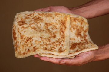 Hands holding Msemmen or Msemen, Traditional moroccan flatbread