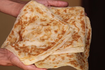 Hands holding Msemmen or Msemen, Traditional moroccan flatbread