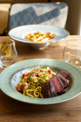 Restaurant-style pasta with grilled steak served at table